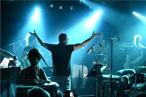 Performance situation of the Fire! Orchestra. Between the spotlights, the people are more like silhouettes.