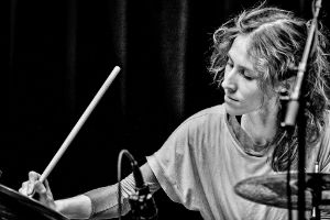 Headshot: Judith Schwarz spielt Schlagzeug.