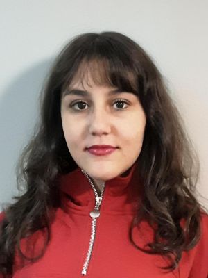 Livana Hussein blickt direkt in die Kamera. Sie hat lange Haare und trägt einen roten Pullover.
