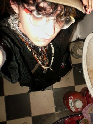 Eine junge Person steht vor einem Waschbecken und fotografiert sich von oben.