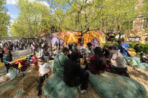 People sitting on a mountain of straw bales