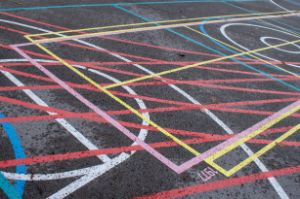 A pattern of coloured lines and circles on asphalt