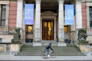 Eine Person fährt auf dem Fahrrad am Gropius Bau vorbei.