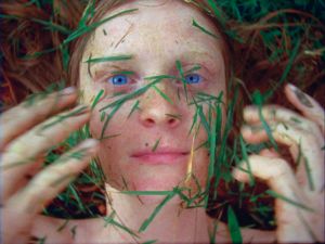 A woman throws cut grass in her face.
