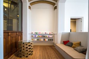 Ein Raum mit einer Sitzbank und einem Bücherregal
