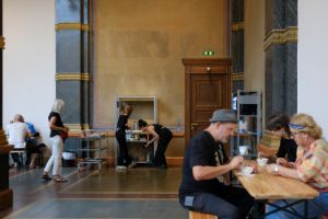 Installationsansicht von Rirkrit Tiravanija's "untitled 1993 (flädlesuppe)" aktiviert von Besucher*innen im Rahmen der Ausstellung "Rirkrit Tiravanija: DAS GLÜCK IST NICHT IMMER LUSTIG" im Gropius Bau, 2024.