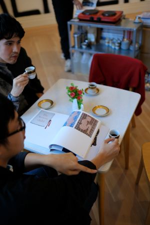 Installationsansicht von Rirkrit Tiravanija's "untitled 1993 (café deutschland)" aktivert durch Besucher*innen im Rahmen der Ausstellung "Rirkrit Tiravanija: DAS GLÜCK IST NICHT IMMER LUSTIG" im Gropius Bau.
