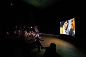 Installation view with visitors of Vaginal Davis' "The Carla DuPlantier Cinerama Dome" as part of the exhibition " Vaginal Davis: Fabelhaftes Produkt" at Gropius Bau, 2025.