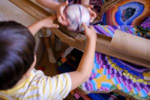 A close-up shot from above, showing two children playing with a ball.