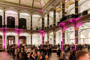 Eine Menschenschlange geht quer durch den Lichthof des Gropius Bau.