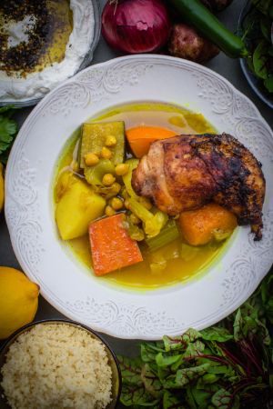 A dish with potatoes, carrots, chickpeas and chicken.