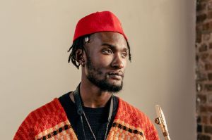 Portrait of Isaiah Collier, also showing the mouthpiece of his soprano saxophone.