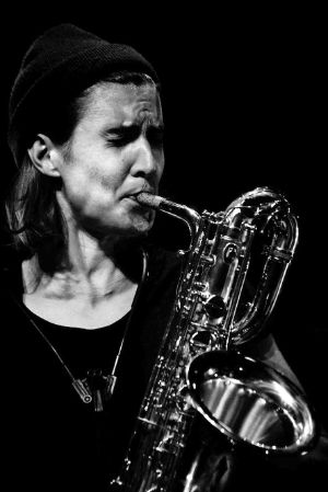 Hanne De Backer plays the saxophone with closed eyes and furrowed brow.