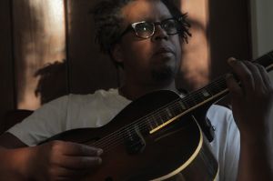 Portrait of Jeff Parker playing guitar.