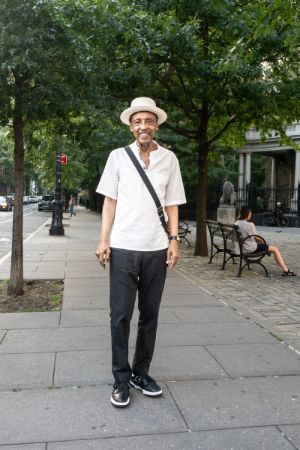 Henry Threadgill steht auf einer Straße mit Bäumen.