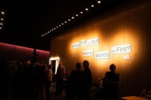 People in the foyer, words on the wall say: Where will you run when the world´s on fire?