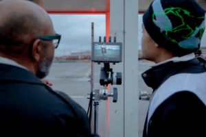 Zwei Personen schauen auf das Aufnahmebild einer Kamera.