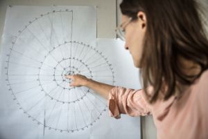 Composer Catherin Lamp points her finger at the sketch of a spiral.