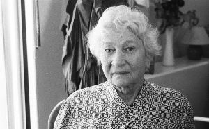 The portrait of the composer Éliane Radigue in black and white. She is wearing a blouse with a square pattern. 