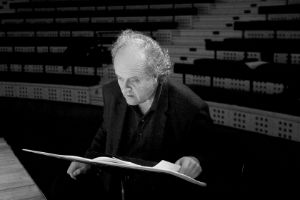 Wolfgang Rihm blättert durch eine Partitur.