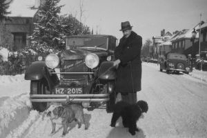 Willem Pijper im Mantel mit zwei Hunden an der Leine