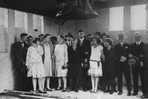 Happy choir community under a hanging church bell