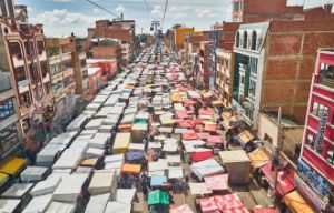 Ansicht einer Straße von oben in Südamerika, die voll von Marktständen ist.