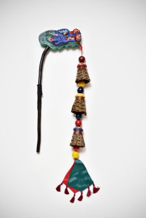 An object in the shape of a dragon's head with feathers and wooden elements.