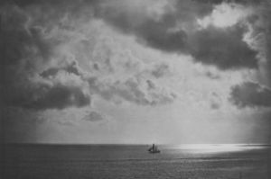 Ein weiter Himmel voller Wolken, unten fährt ein Schiff auf dem Meer.