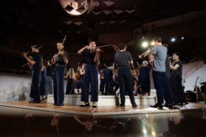 Musicians play on a stage in an inner and an outer circle.