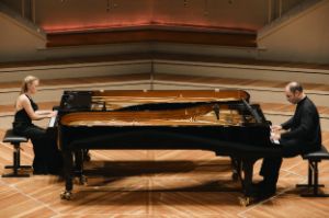 Alexander Melnikov and Olga Pashchenko play opposite each other on two pianos pushed together.