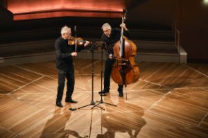 On an otherwise empty stage, Helge Slaatto plays the violin next to Frank Reinecke on the double bass.