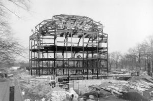 Baustelle mit aufgebautem Stahlgerüst und Fundament und einzelnen Arbeitern.