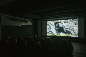 Ein Kinosaal, in dem gerade ein Film vor Publikum läuft.