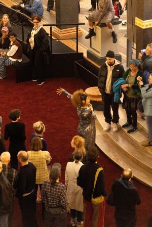 Der volle Lichthof des Gropius Bau, bei der Eröffnung der Ausstellung Ligia Lewis: Ligia Lewis: I’M NOT HERE FORRRRR… In der MItte der Besuchenden steht eine performenen Person.