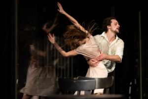 In a sweeping movement, one person grabs another around the stomach