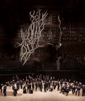 The Finnish Radio Symphony Orchestra stands beneath the large stage decoration of an artificial, abstract tree.