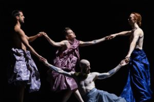 Four dancers hold hands.