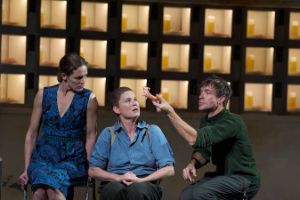 Szene aus der Inszenierung „Automatenbüfett“, der Schauspieler Christopher Luser hält ein Stück Wurst in die Höhe, die Schauspielerinnen Katharina Lorenz und Dörte Lyssewski sehen ihm zu.