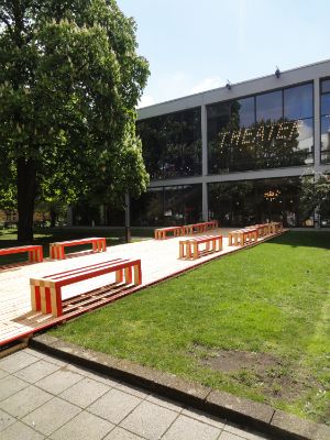 Wooden benches are placed in front of the Haus der Berliner Festspiele.