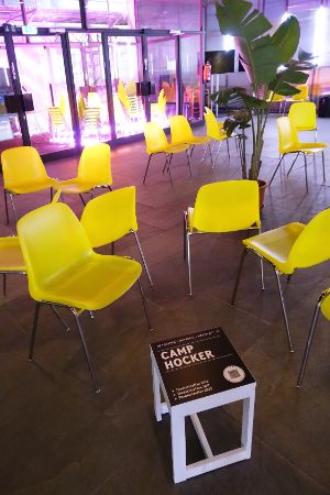 A stool stands by yellow chairs in the Festspielhaus.