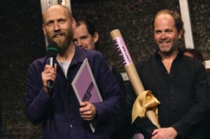 Ward Weemhoff and Vincent Rietveld smiling and holding the accolade in honour of the artists and poster roll.