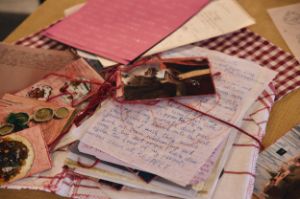 A collection, decorated with cloth and string, of handwritten texts and pictures of food.
