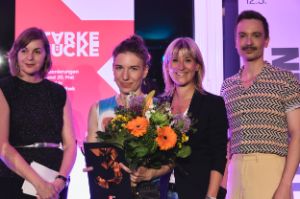Mirjam Stängl stands next to three other people, a bouquet of flowers and 3sat prize in hand.