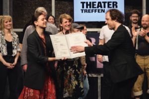 Olena Apchel and Carolin Hochleichter present the team of "Hamlet" with an accolade in honour of the artists.