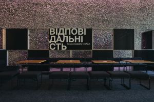 Empty chairs and tables are in front of a sign saying “Responsiblity Treffen”.