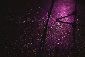 Colourful confetti on a purple illuminated stage floor.