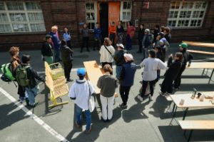 Ein Gruppe von Menschen steht im Kreis vor den Uferstudios.