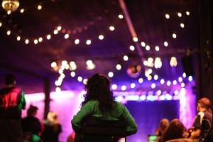 Eine Party im Haus der Berliner Festspiele. Bunte Lichterketten hängen von der Decke.