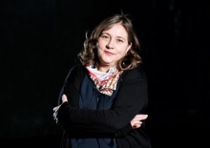 Foto von einer Frau vor schwarzem Hintergrund.
